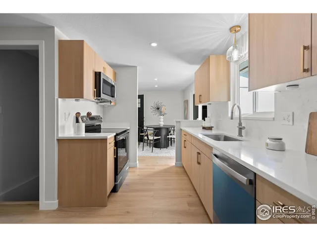 a large kitchen with stainless steel appliances a sink and cabinets