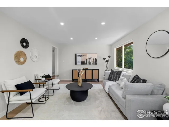 a living room with furniture a rug and a window