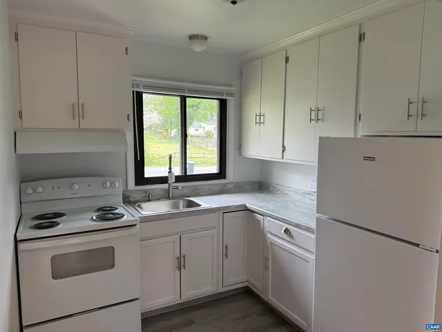 a kitchen with cabinets appliances a sink and a window