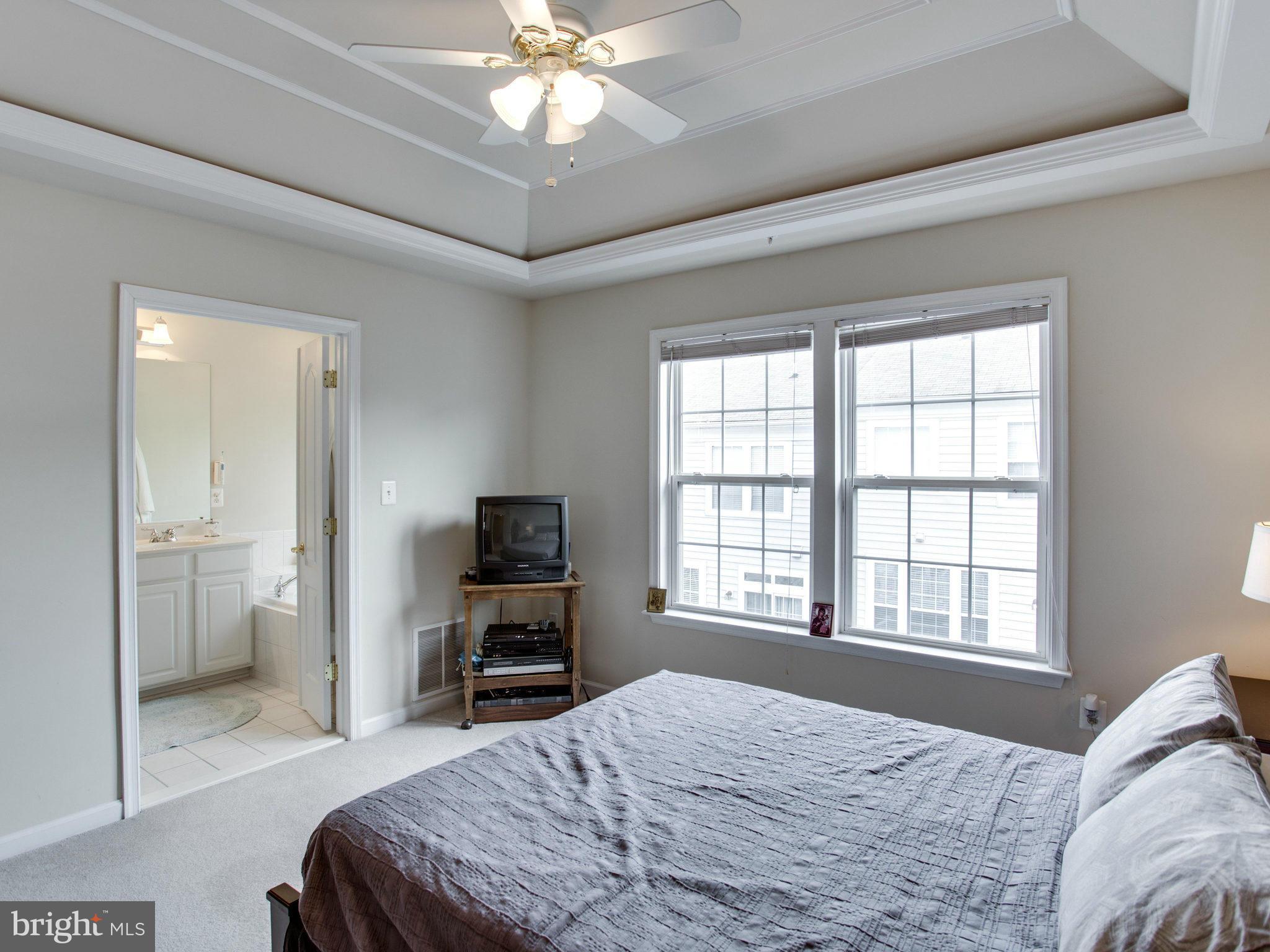 9823 Darcy Forest Drive Silver Spring, MD 20910 - Photo 24 of 30 a bedroom with a bed a flat screen tv and a chandelier