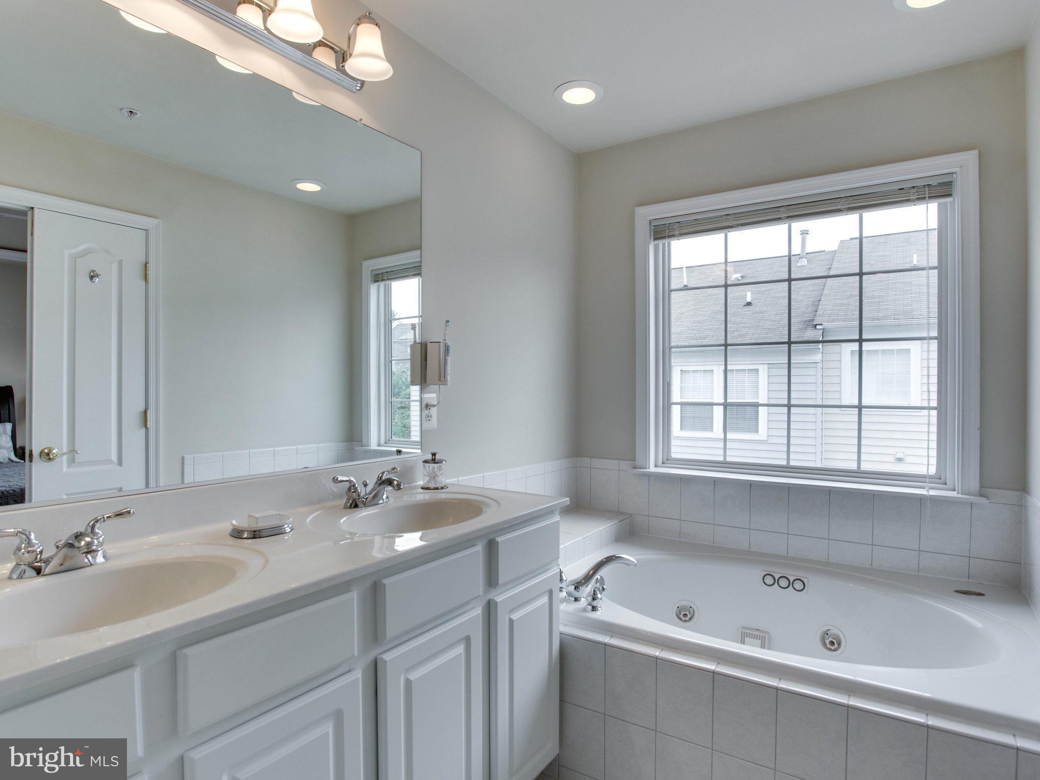 9823 Darcy Forest Drive Silver Spring, MD 20910 - Photo 26 of 30 a bathroom with a tub a sink and mirror