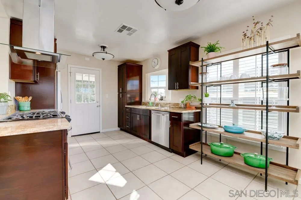 6244 Lorca Drive San Diego, CA 92115 - Photo 7 of 25 a open kitchen with stainless steel appliances granite countertop a stove top oven a sink dishwasher and a refrigerator with wooden floor
