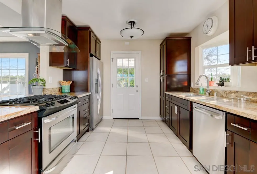 6244 Lorca Drive San Diego, CA 92115 - Photo 8 of 25 a kitchen with stainless steel appliances granite countertop a stove and a sink
