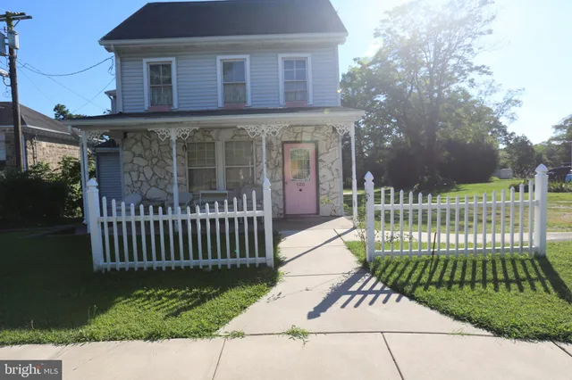 a view of a brick house with a small yard and plants