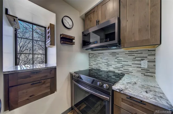 a kitchen with granite countertop a stove and a microwave