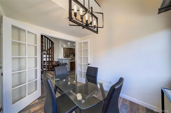 a view of a dining room with furniture a rug and wooden floor