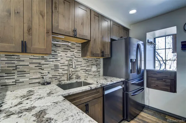 a kitchen with granite countertop a refrigerator and a stove