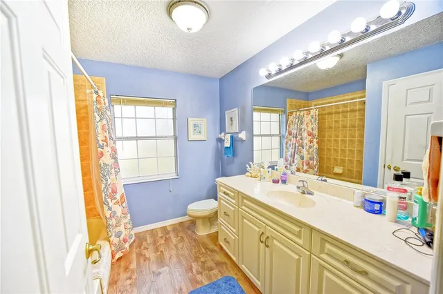 a bathroom with a sink a large mirror and a bathtub next to a window