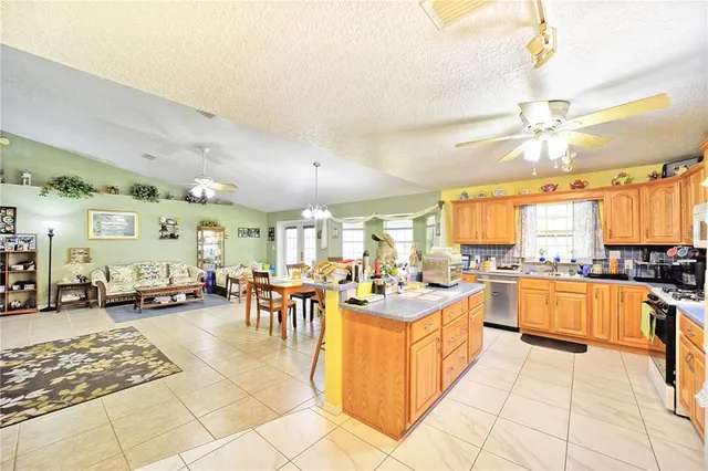a large white kitchen with lots of counter top space and stainless steel appliances