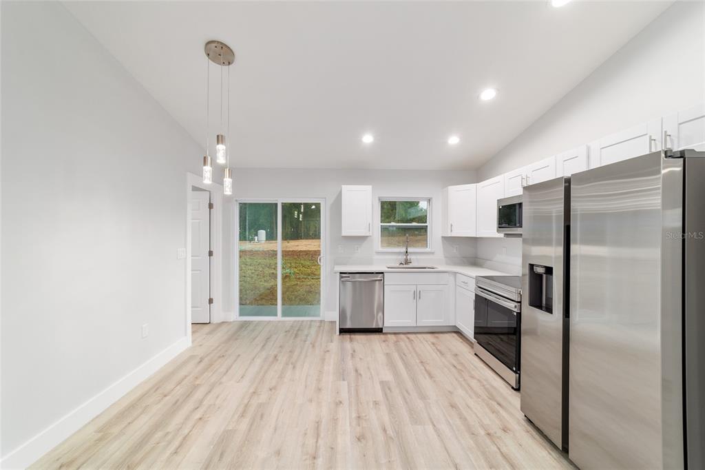 15776 Southwest 27th Lane Ocala, FL 34481 - Photo 18 of 39 a kitchen with a refrigerator a sink and cabinets