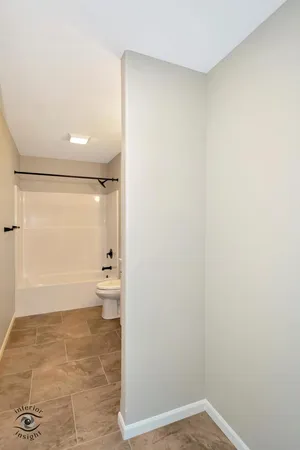 a bathroom with a granite countertop toilet and a shower