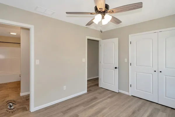 an empty room with fan and entrance