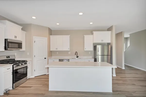 a kitchen with stainless steel appliances a refrigerator stove top oven and cabinets