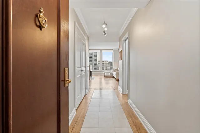 a view of a hallway with wooden floor and tub
