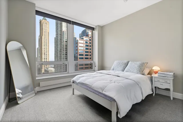 a bedroom with a bed a mirror and a window