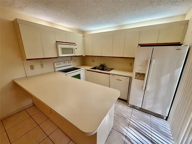 a kitchen with stainless steel appliances a refrigerator sink and microwave