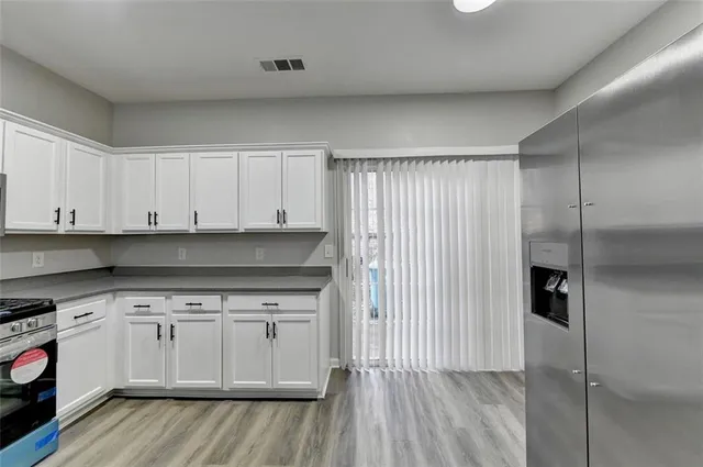 a kitchen with a white cabinets and wooden floor
