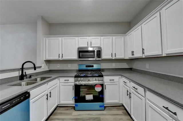 a kitchen with white cabinets and stainless steel appliances