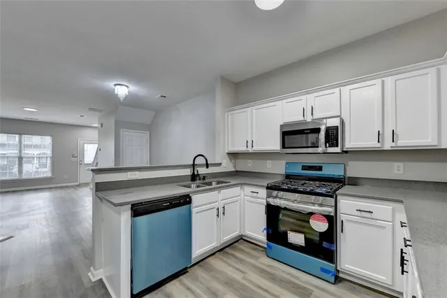 a kitchen with stainless steel appliances granite countertop a stove a sink and a microwave