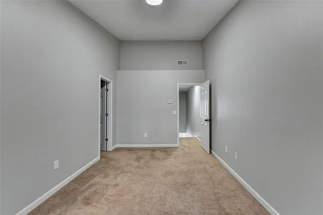 an empty room with closet and mirror