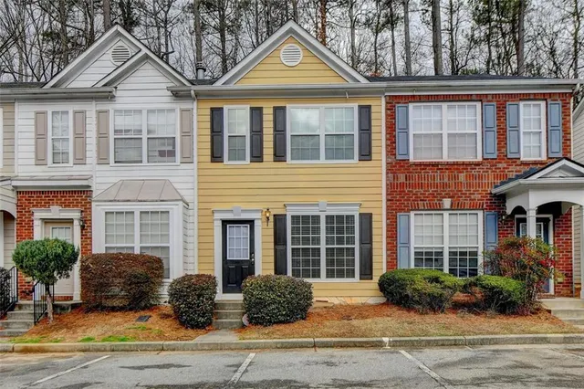 a front view of a house with a yard and potted plants