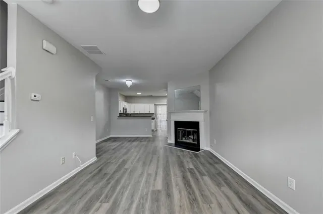 a view of empty room with a fireplace and wooden floor