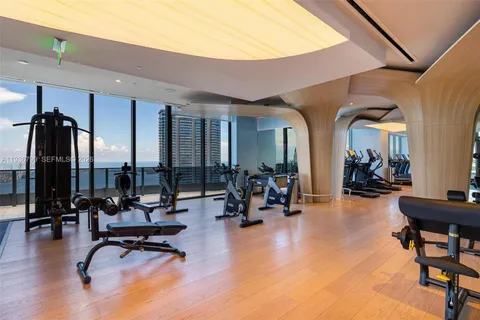 a view of a livingroom with furniture and a gym cycle