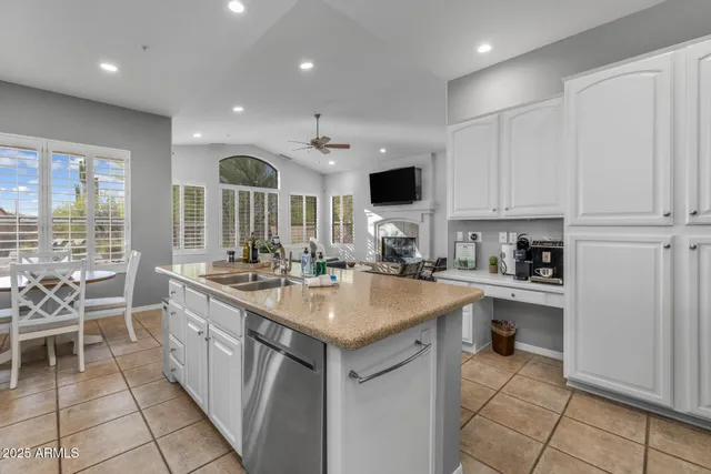 a kitchen with stainless steel appliances granite countertop a stove a sink a microwave a dining table and chairs