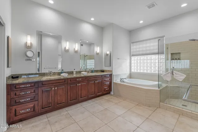 a bathroom with a granite countertop tub shower and sink