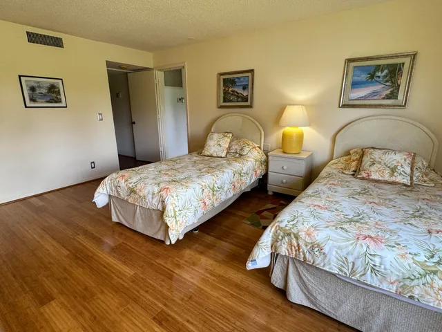a bedroom with a bed wooden floor and window
