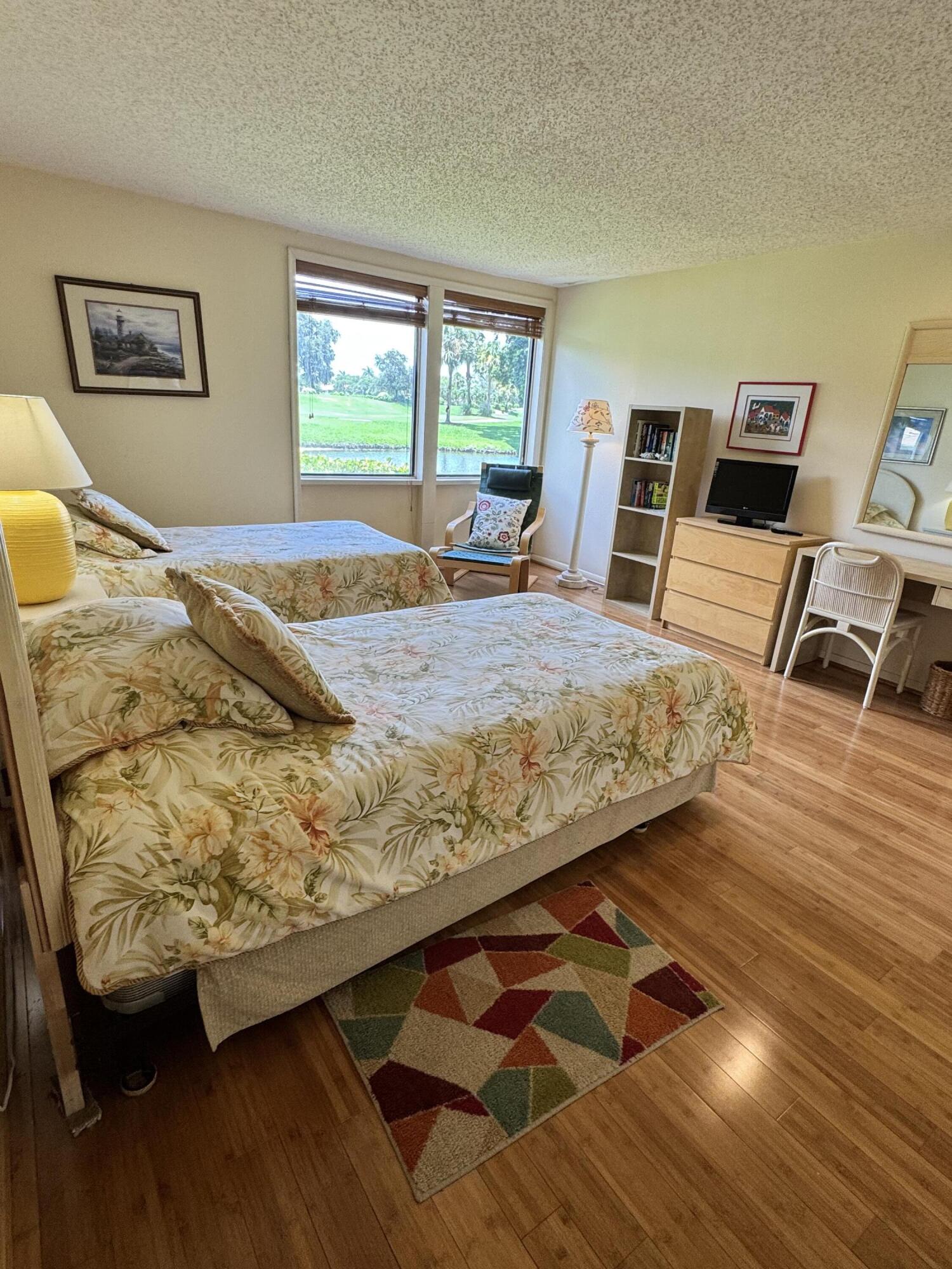 20061 Boca W Drive Boca Raton, FL 33434 - Photo 6 of 8 a bedroom with a bed wooden floor and window