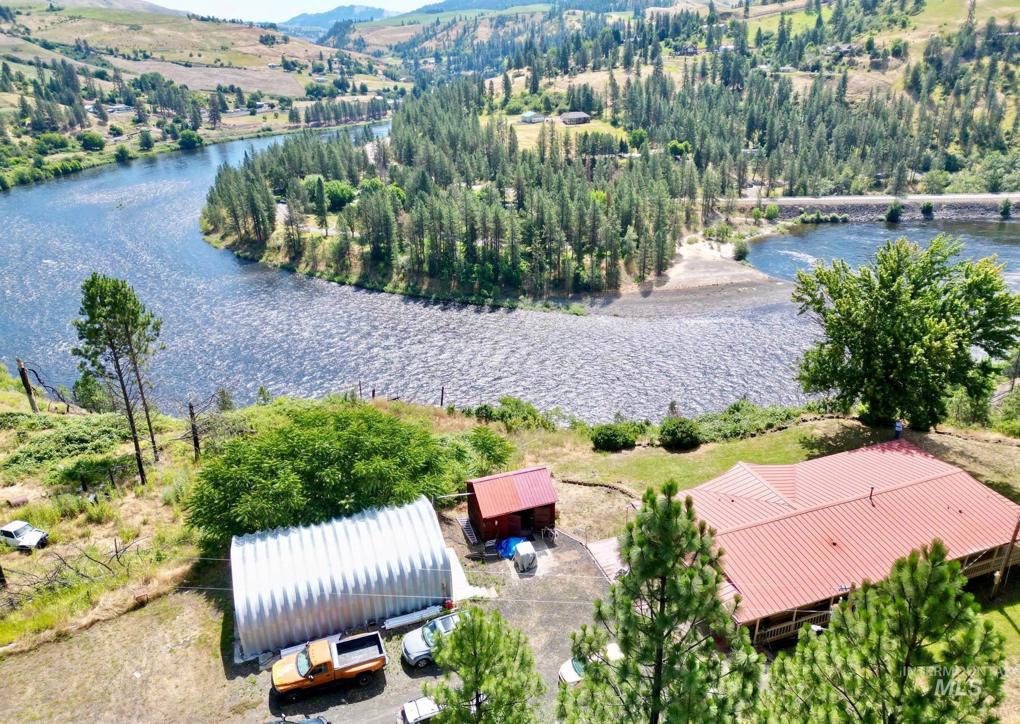 35322 River Road Lenore, ID 83541 - Photo 1 of 42 Expansive riverfront property featuring a red metal roof residence and a large Quonset hut