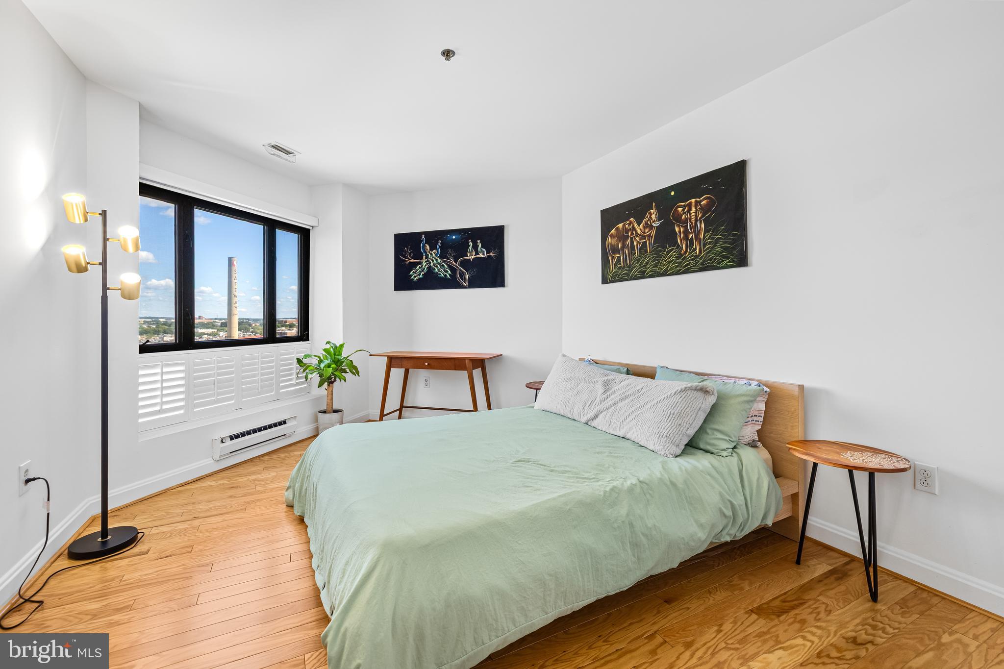 2515 Boston Street, Unit 1206 Baltimore, MD 21224 - Photo 22 of 29 a spacious bedroom with a bed and a desk