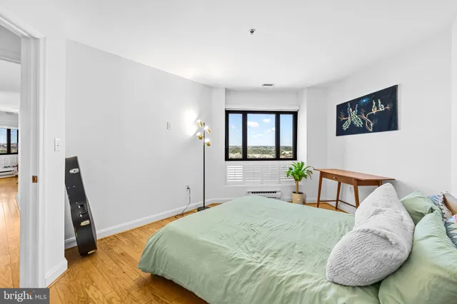 a bedroom with a bed a couch and a window