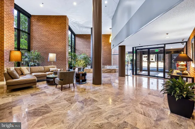 a living room with furniture potted plant floor and large window