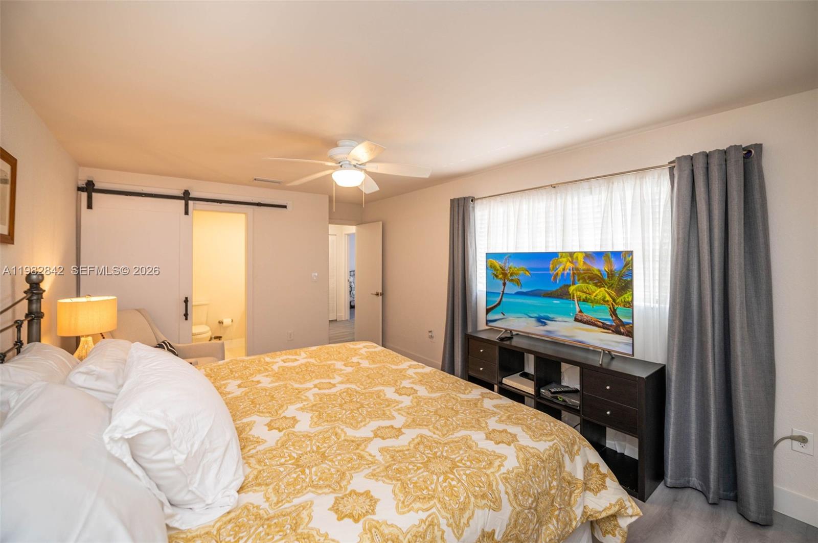 4702 Southwest 67th Avenue, Unit O7 Miami, FL 33155 - Photo 13 of 32 a bedroom with a bed and a flat screen tv
