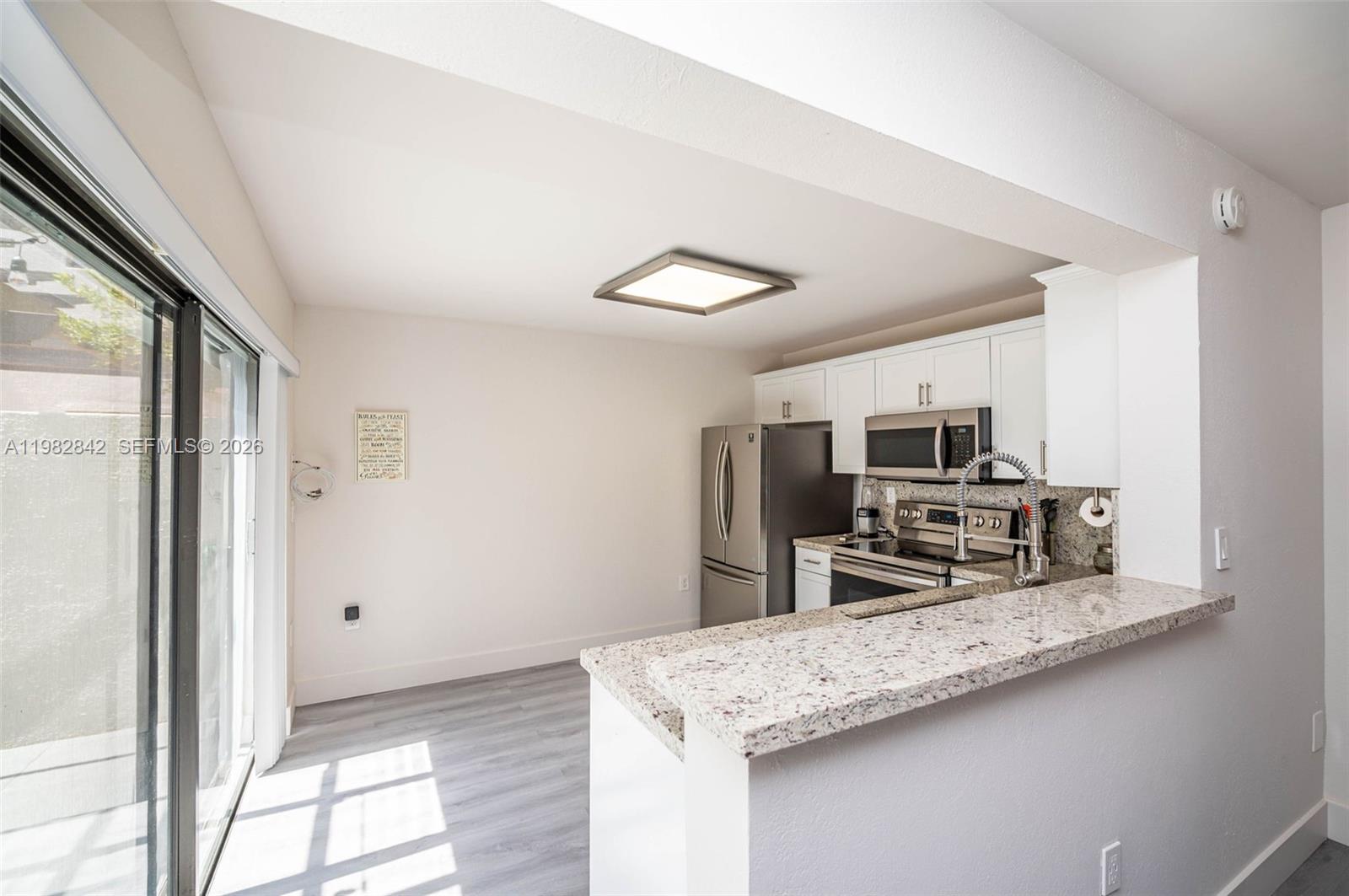 4702 Southwest 67th Avenue, Unit O7 Miami, FL 33155 - Photo 8 of 32 a kitchen with stainless steel appliances granite countertop a sink stove and refrigerator