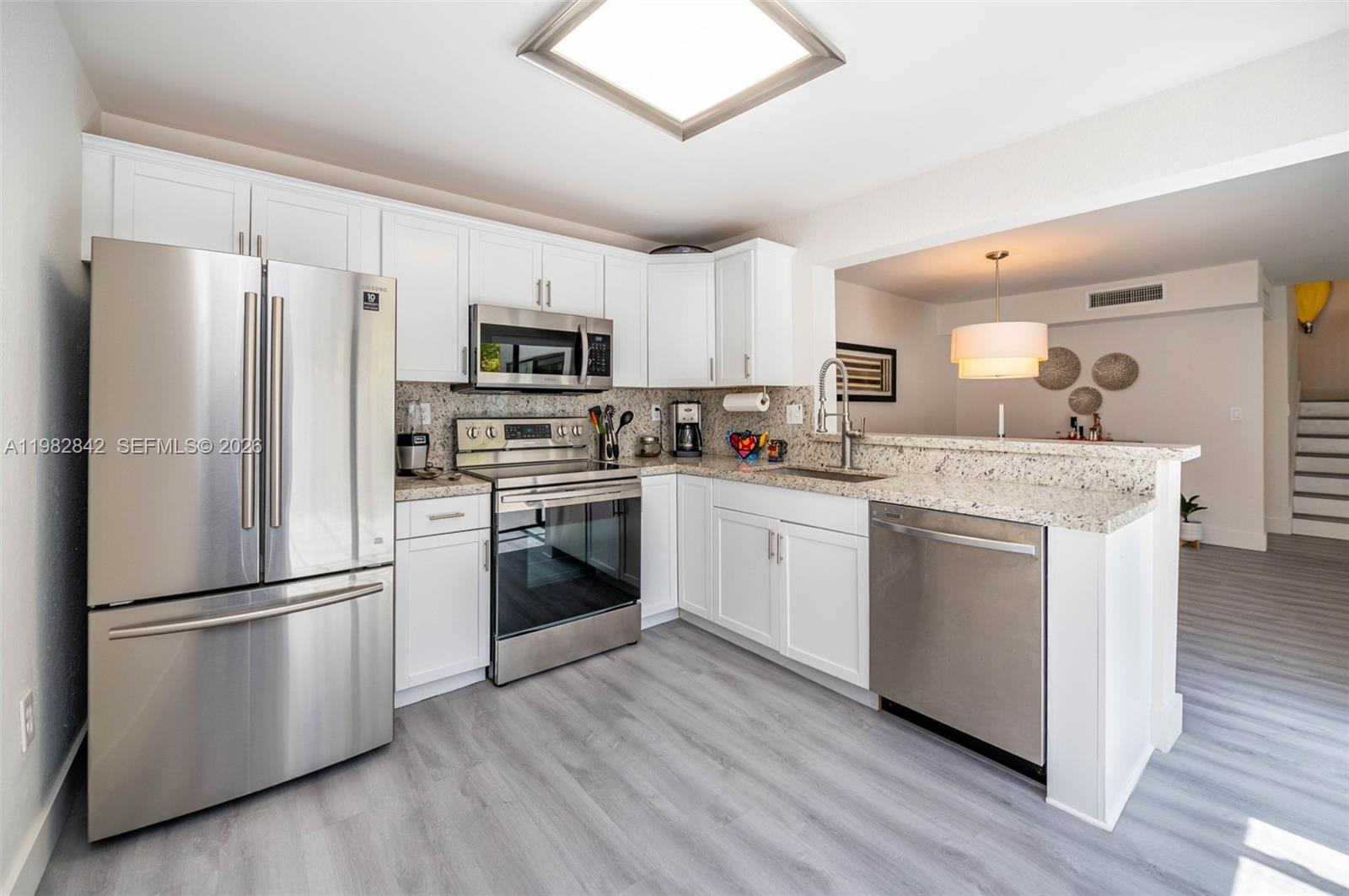 4702 Southwest 67th Avenue, Unit O7 Miami, FL 33155 - Photo 9 of 32 a kitchen with a refrigerator stove and sink