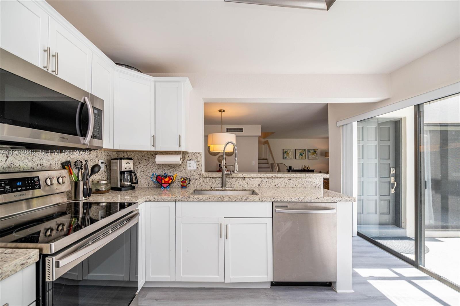 4702 Southwest 67th Avenue, Unit O7 Miami, FL 33155 - Photo 10 of 32 a kitchen with stainless steel appliances white cabinets and a sink