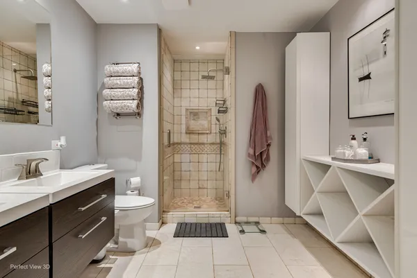 a bathroom with a double vanity sink a toilet and shower