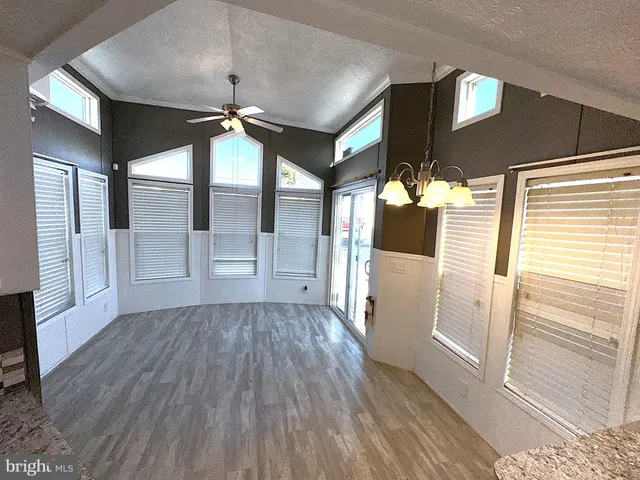 a view of a hallway with wooden floor and glass door