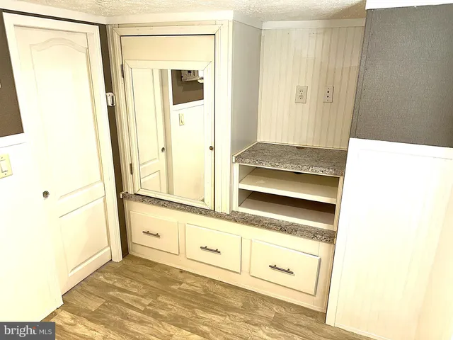 a bathroom with a granite countertop toilet sink and mirror