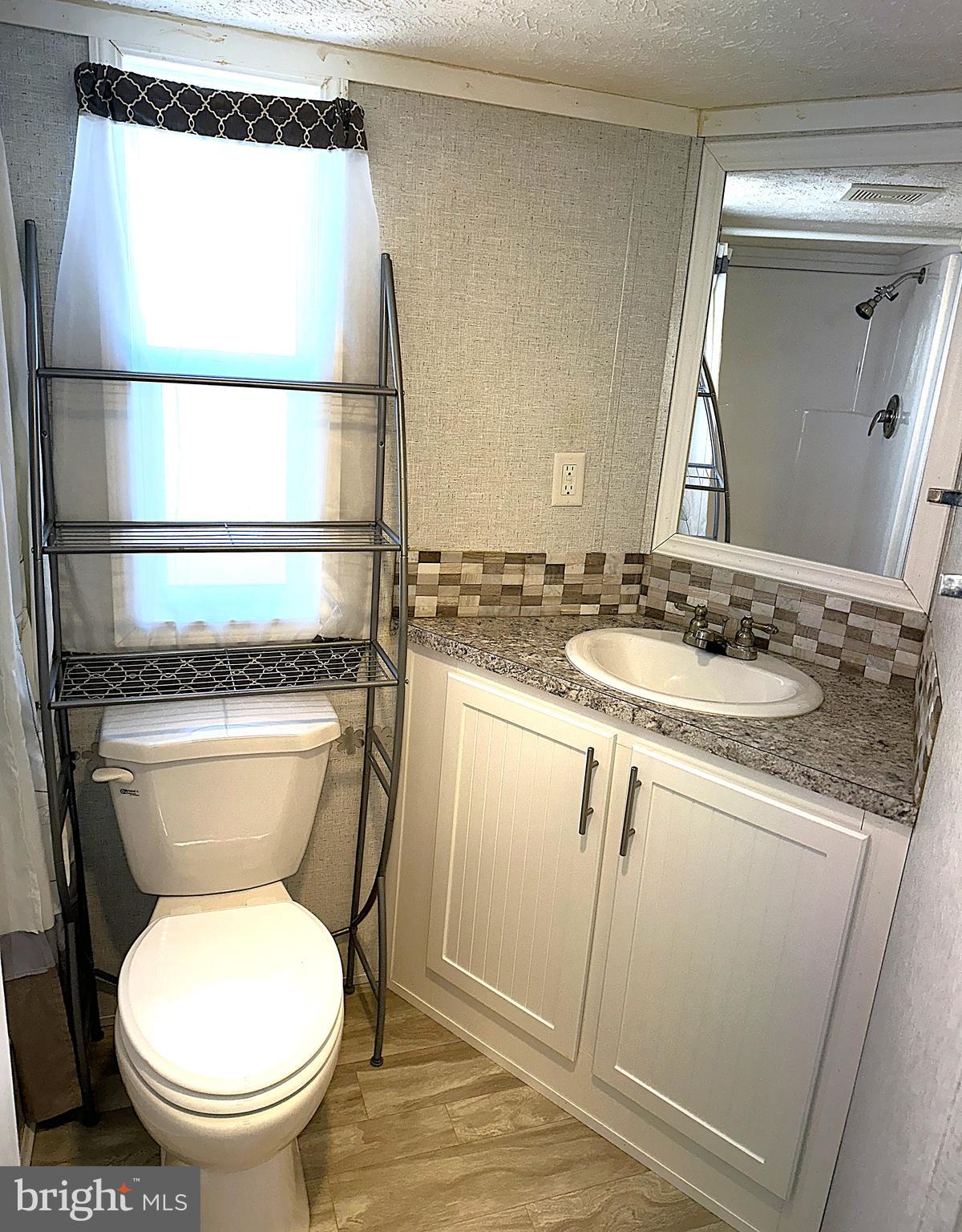 56 3rd Street Lothian, MD 20711 - Photo 17 of 25 a bathroom with a granite countertop toilet sink and mirror