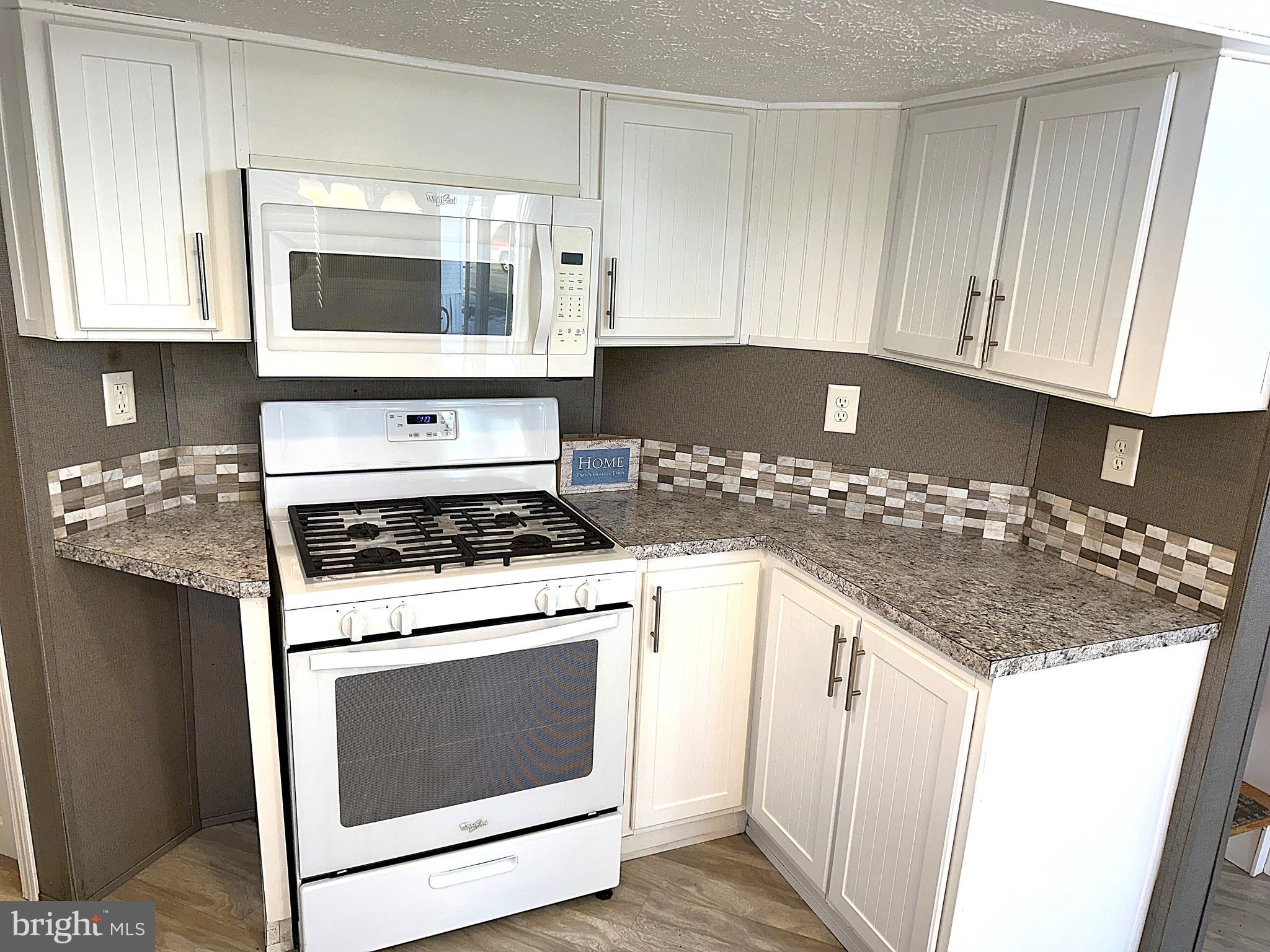 56 3rd Street Lothian, MD 20711 - Photo 4 of 25 a kitchen with granite countertop white cabinets and white appliances
