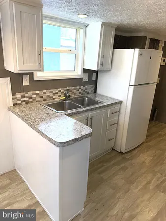 a kitchen with granite countertop a sink and a refrigerator