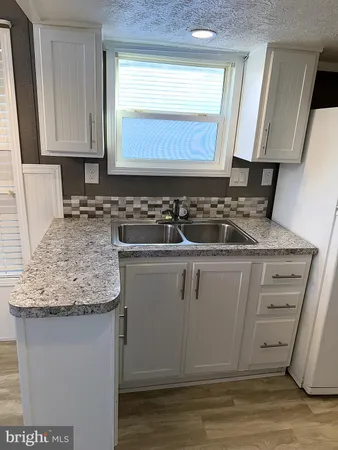 a kitchen with granite countertop a sink and a stove