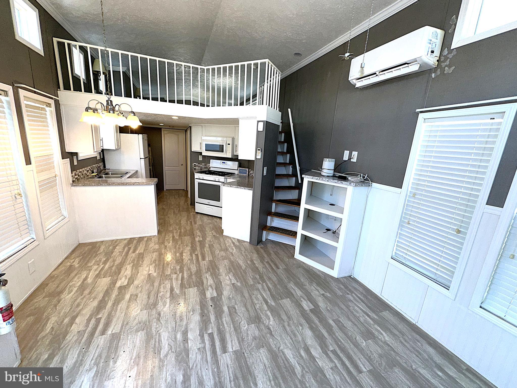 56 3rd Street Lothian, MD 20711 - Photo 8 of 25 a view of a hallway with wooden floor windows and a kitchen view