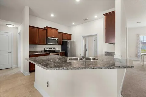 a bathroom with a granite countertop sink toilet a large mirror a shower and a tub