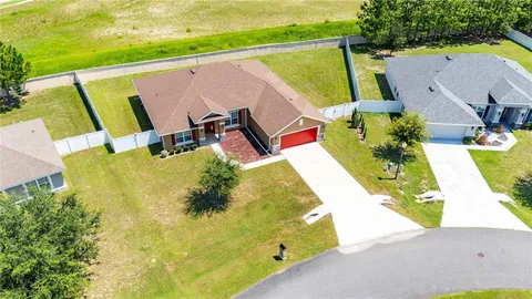 a view of a swimming pool with lawn chairs and plants