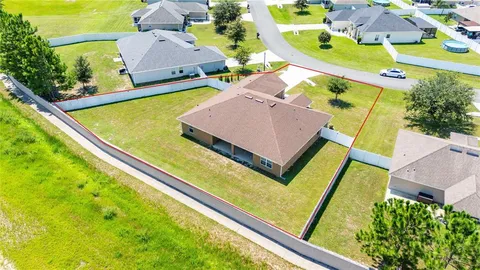 an aerial view of residential houses with outdoor space and trees